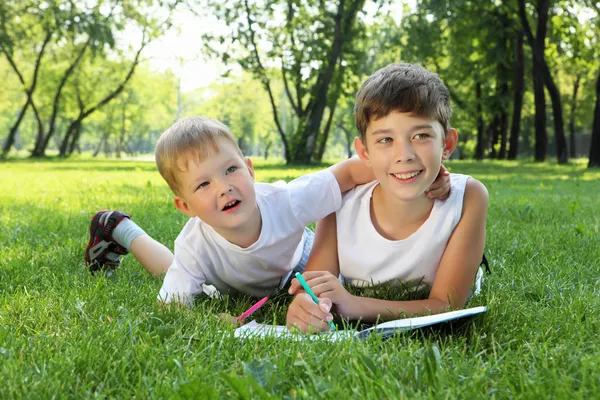 Kinderen in het park lezen van een boek — Stockfoto