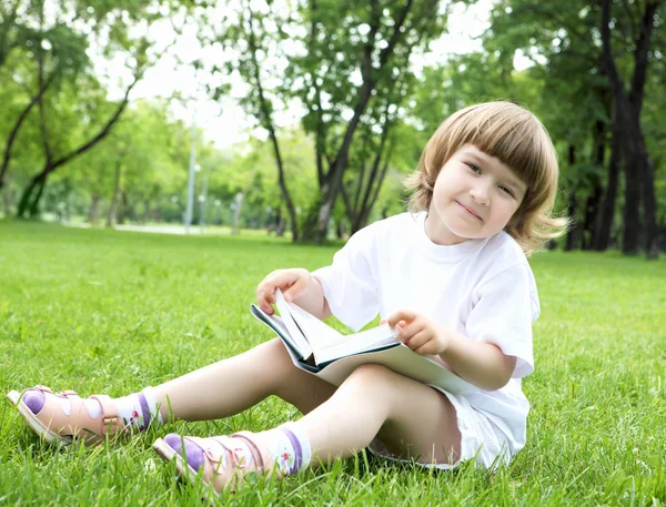 Πορτρέτο της κοριτσάκι, διαβάζοντας ένα βιβλίο στο πάρκο — Φωτογραφία Αρχείου