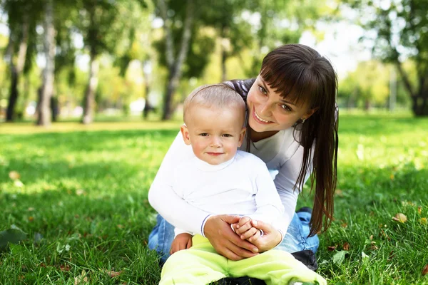 Νεαρή μητέρα με τον γιο της σε πάρκο καλοκαίρι — Φωτογραφία Αρχείου