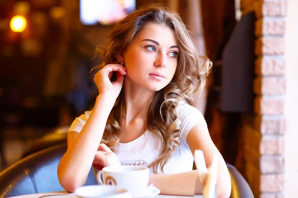 Mladá krásná žena, sedící v restauraci — Stock fotografie