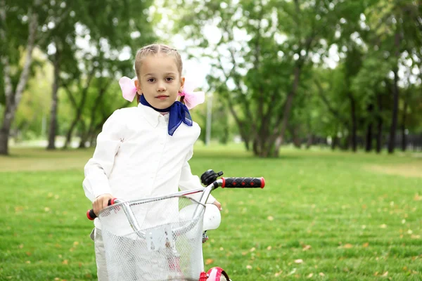 Meisje op een fiets in het groene park — Stockfoto
