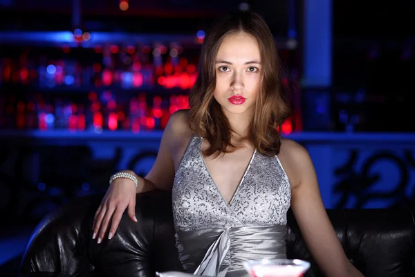 Молодая женщина в ночном клубе с напитком — стоковое фото
