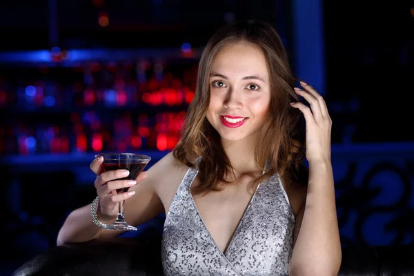 Jonge vrouw in nachtclub met een drankje — Stockfoto