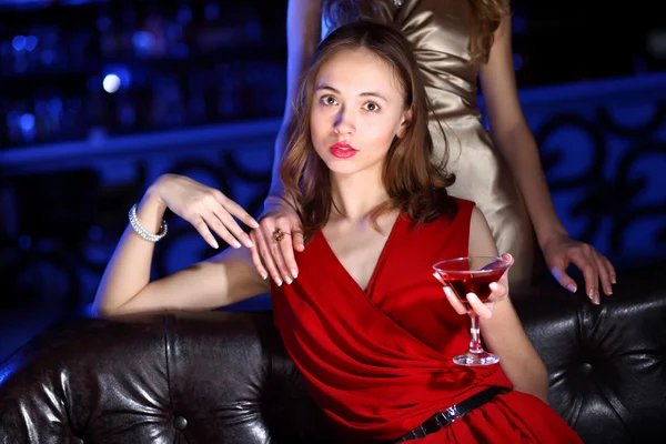 Молодая женщина в ночном клубе с напитком — стоковое фото