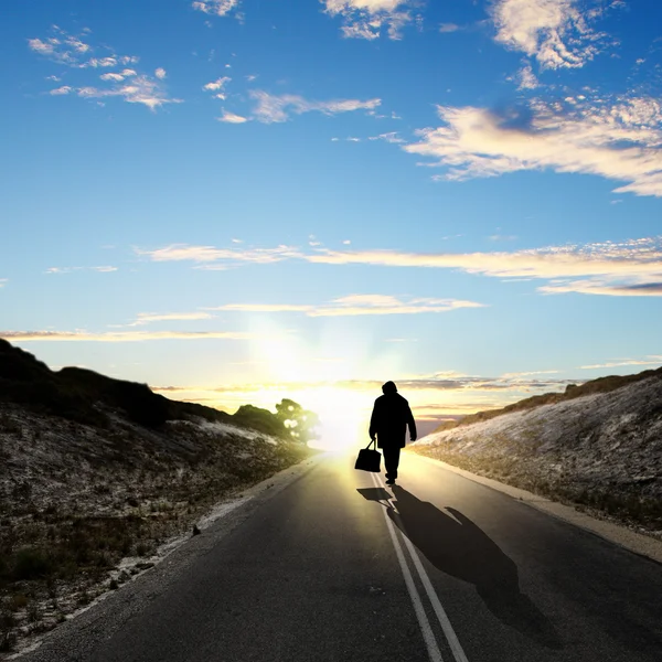 Muž odcházet za svítání po silnici — Stock fotografie