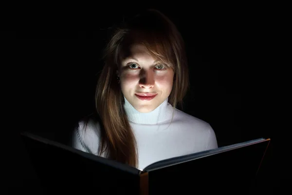 Young woman reading a magic book — Stockfoto