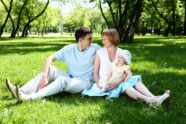 Young family together in the park — Stock Photo, Image