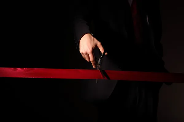 Бізнесмен з ножицями ріже червону стрічку — стокове фото