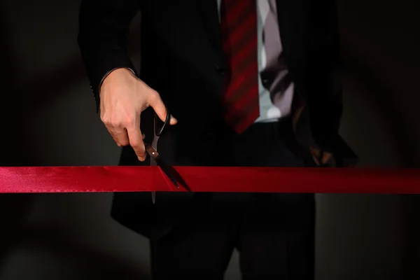 stock image Businessman with scissors cuting a red ribbon