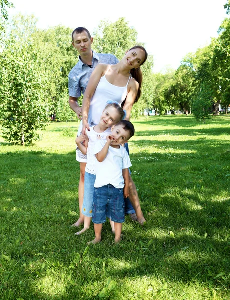 Kahden lapsen perhe kesäpuistossa — kuvapankkivalokuva