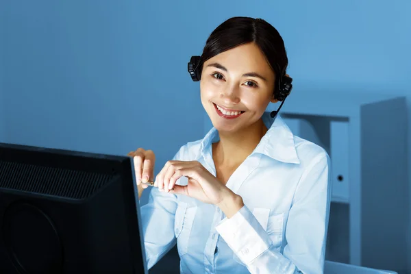 Junge Frau in Businesskleidung und Headset — Stockfoto