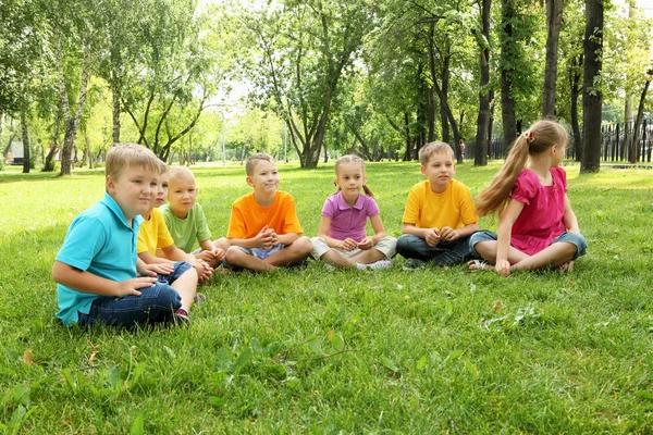 Group of children sitting together in the park — Stock Photo, Image