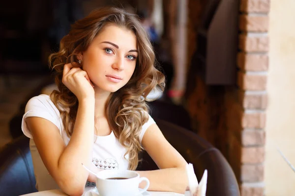 Молодая красивая женщина сидит в ресторане — стоковое фото