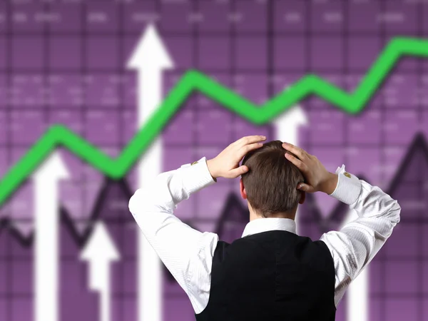Young businessman against financial graphs — Stock Photo, Image