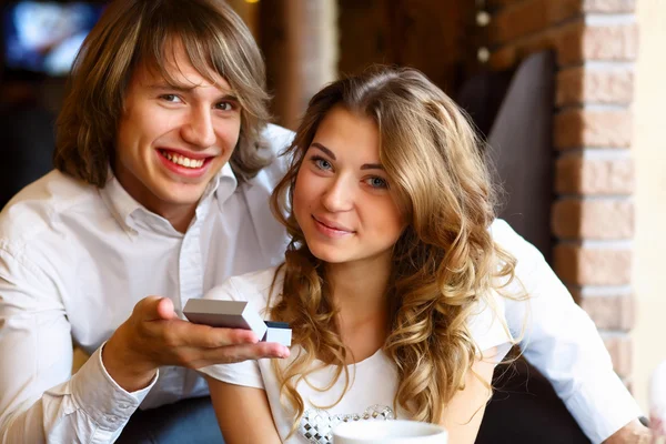 Mladý pár s zásnubní prsten v restauraci — Stock fotografie