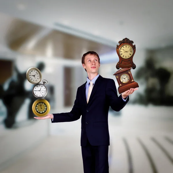 Podnikatel v úřadu drží hodiny pyramida — Stock fotografie