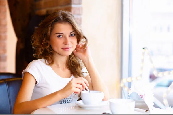 Jonge mooie vrouw zitten in restaurant — Stockfoto