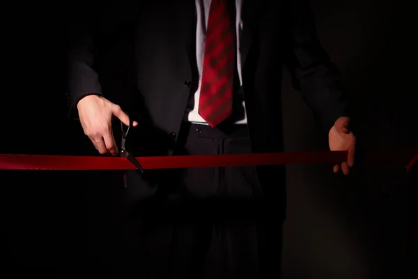 stock image Businessman with scissors cuting a red ribbon