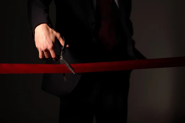 stock image Businessman with scissors cuting a red ribbon