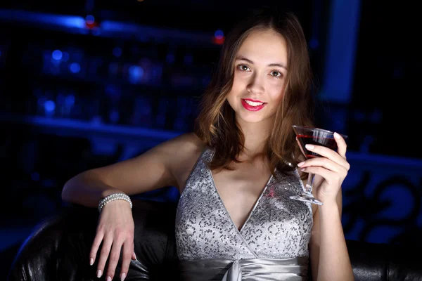 Jeune femme en boîte de nuit avec un verre — Photo