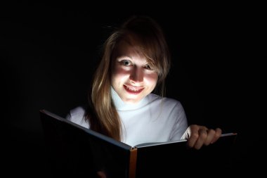 Young woman reading a magic book