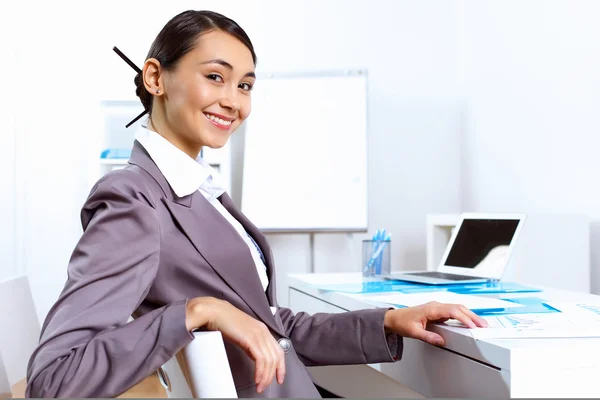 Молодая женщина в деловой одежде работает в офисе — стоковое фото