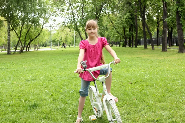 Дівчина з велосипедом у парку — стокове фото