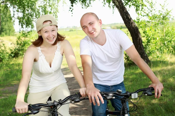 骑自行车在公园里的年轻夫妇 — 图库照片