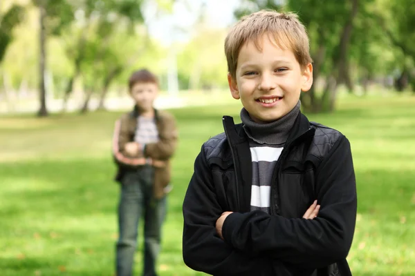 Chlapec s přítelem v zeleném parku — Stock fotografie