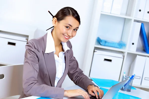 Jonge vrouw in zakelijke slijtage werken in office — Stockfoto