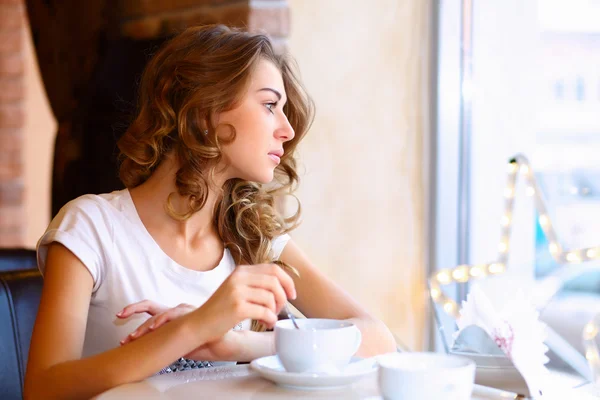 Young pretty woman sitting in restaurant Stock Image