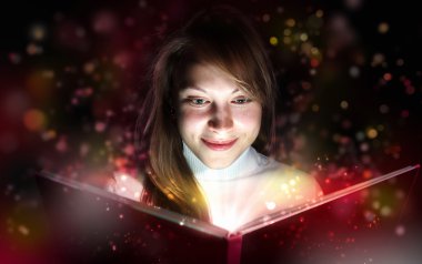 Young woman reading a magic book