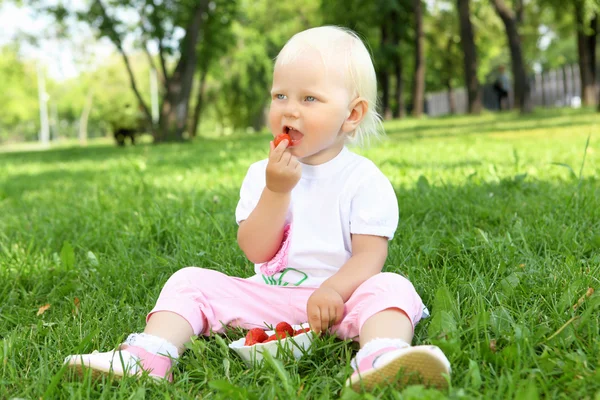 Niña con fresas al aire libre — Foto de Stock