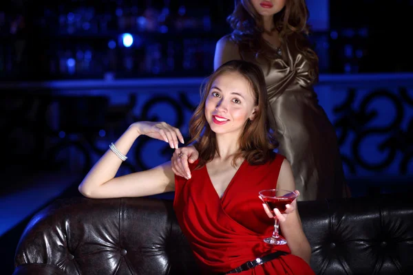 Mujer joven en el club nocturno con una bebida — Foto de Stock