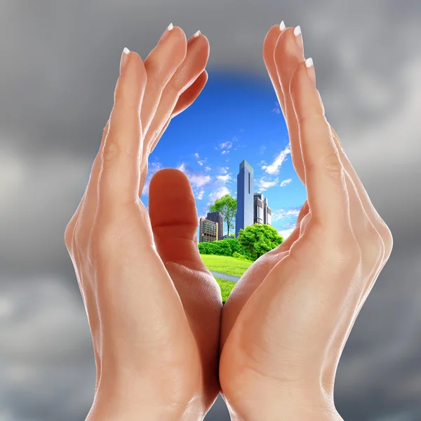 Human hands and house against blue sky — Stockfoto