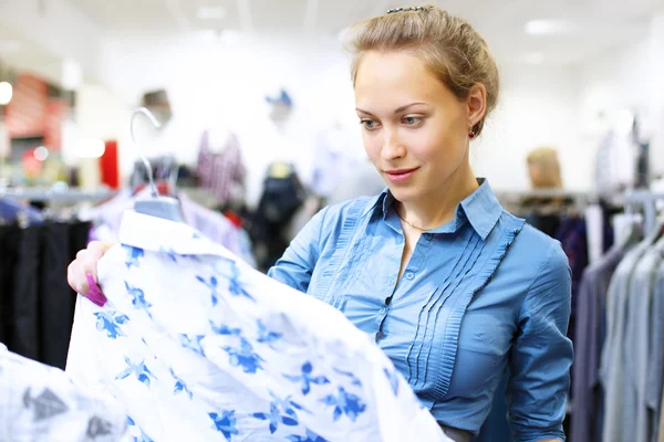 Kvinna i en butik köper kläder — Stockfoto