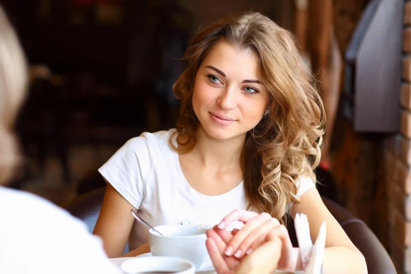 Unga vackra kvinnan sitter i restaurangen — Stockfoto