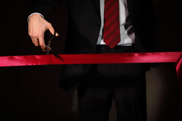 stock image Businessman with scissors cuting a red ribbon