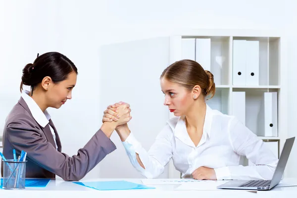 Young women arm wrestling in office — Stock Photo, Image