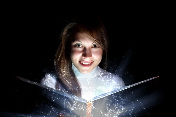 Young woman reading a magic book — Stockfoto