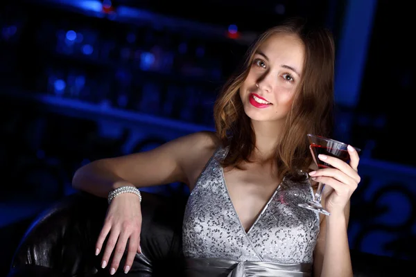 Jeune femme en boîte de nuit avec un verre — Photo