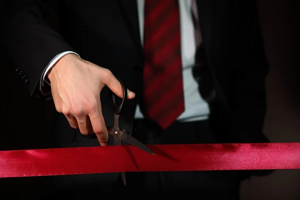 stock image Businessman with scissors cuting a red ribbon