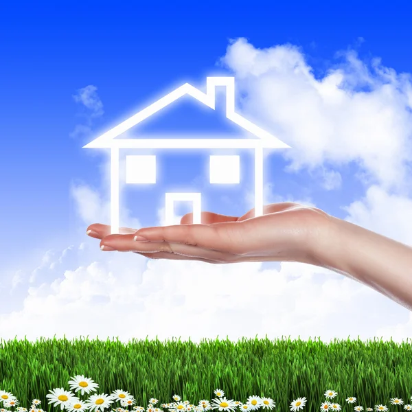 Hus och mänsklig hand mot blå himmel — Stockfoto