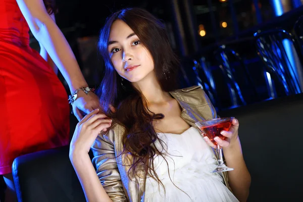 Atraktivní žena v nočním klubu s nápojem — Stock fotografie