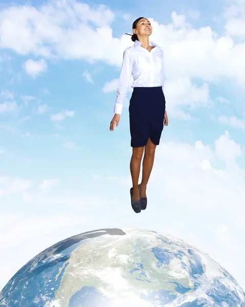 Молодая женщина прыгает и наша планета Земля — стоковое фото