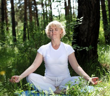 Yaşlı bir kadın yoga yapıyor.