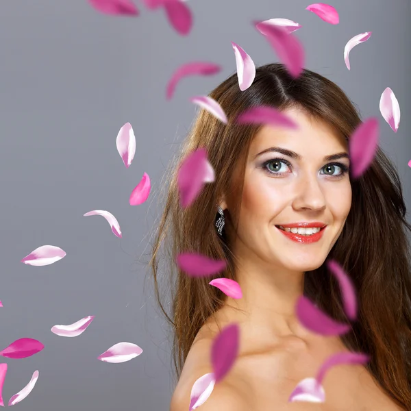Jonge vrouw met bloemen op achtergrond — Stockfoto