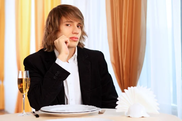 レストランに座っている若いハンサムな男 — ストック写真