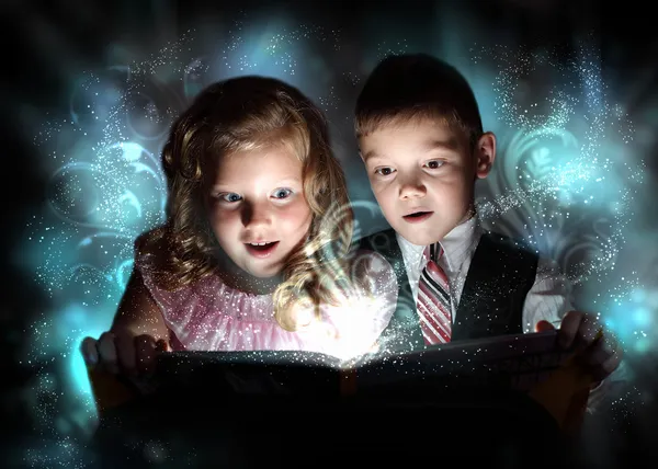 Lapset avaavat taika lahjapakkauksen — kuvapankkivalokuva