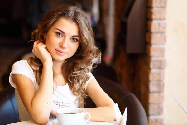 Jonge mooie vrouw zitten in restaurant — Stockfoto